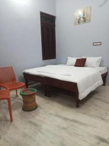 a bed in a room with a chair and a bed sqor at Krishna hotel and restro in Jaipur