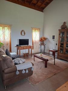 a living room with a couch and a table at Chalé Araucárias-Recanto dos pássaros in Cambuí