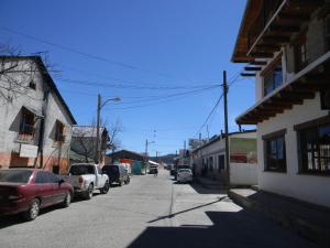 a street with cars parked on the side of the road at La Troje de Adobe in Creel