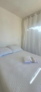 a white bed with a towel on it in a room at Pousada Girassol Genipabu in Extremóz +1 photo