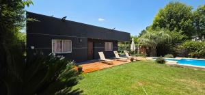 a black house with a pool and a yard at Casa quinta Camino al Sol in Junín