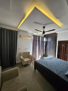 a bedroom with a bed and a chair and a ceiling fan at The High View in Mohali +14 photos