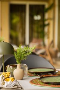 a table with plates and a vase with a plant on it at Estrepão House in Moreira de Conegos