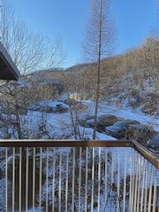 a balcony with snow on the ground next to a river at Location duplex ,Station du Seignus d'Allos in Allos