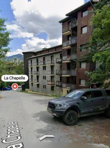 a truck parked in a parking lot in front of a building at Location duplex ,Station du Seignus d'Allos in Allos +3 photos