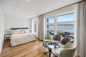 a bedroom with a bed and a table and chairs at Hotel West in Patreksfjörður +43 photos