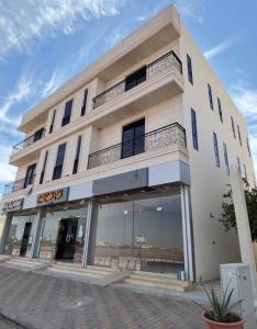 a large white building with a store front at شقق لولو in Hail