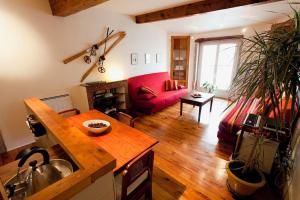 a living room with a red couch and a table at Historic Centre Studio, St-André & Bastille view! in Grenoble