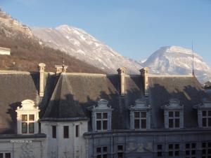 an old building with a mountain in the background at Historic Centre Studio, St-André & Bastille view! in Grenoble