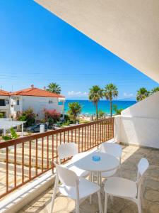 a balcony with a table and chairs and the ocean at Ioli Beach in Skala Fourkas