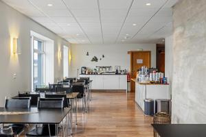 a restaurant with tables and chairs and a counter at Hotel West in Patreksfjörður