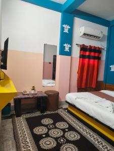 a bedroom with a bed and a mirror and a table at Hotel Lotus in kolkata +2 photos