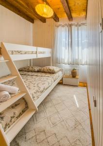 a bedroom with two bunk beds and a window at Velebit House in Baške Oštarije