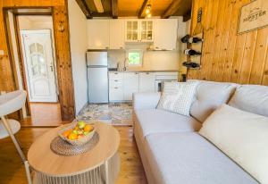 a living room with a couch and a bowl of fruit on a table at Velebit House in Baške Oštarije