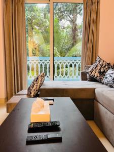 a living room with a couch and a large window at Verdant vista Goa in Cunchelim