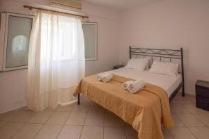 a bedroom with a bed with towels on it at Kratounis Apartment 2 in Oikonomiánika