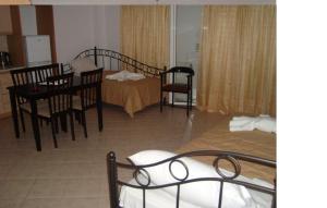 a room with two beds and a table and chairs at Kratounis Apartment 2 in Oikonomiánika