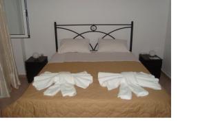 a bedroom with a bed with white towels on it at Kratounis Apartment 2 in Oikonomiánika