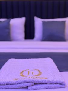 a towel on a bed with two identical beds at FOURTOWERShotel in Ijoko Lemode +10 photos