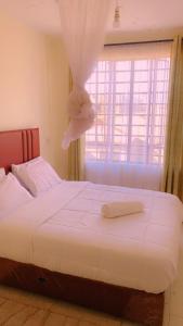a bedroom with a bed with a stuffed animal on it at Moh airbnbs in Kisumu