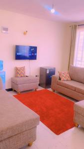 a living room with two couches and a red rug at Moh airbnbs in Kisumu