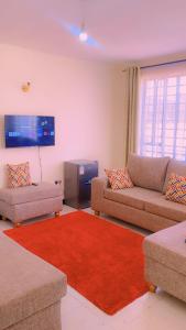 a living room with two couches and a red rug at Moh airbnbs in Kisumu