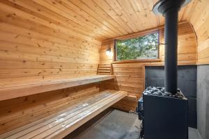 a sauna with a stove in a wooden cabin at Loma House in Sawyer