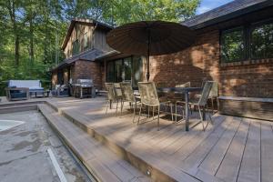 an outdoor deck with a table and chairs and an umbrella at Loma House in Sawyer
