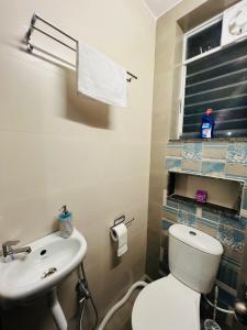 a bathroom with a white toilet and a sink at Verdant vista Goa in Cunchelim +17 photos