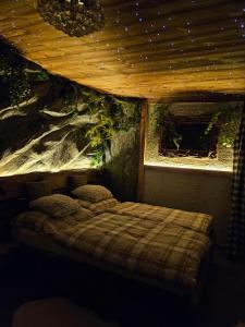 a bedroom with a bed in a room with a ceiling at Chatka Bystrá jacuzzi,stars,river in Bystrá