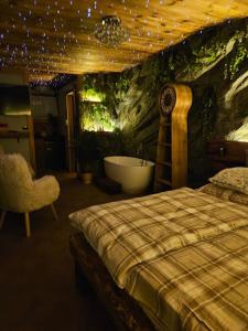 a bedroom with a tub and a bed and a bath room at Chatka Bystrá jacuzzi,stars,river in Bystrá