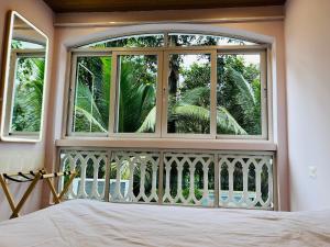 a bedroom with a large window and a bed at Verdant vista Goa in Cunchelim