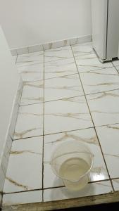 a white tiled floor with a bowl on it at Loft Conteiner in Primavera do Leste
