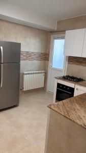 a kitchen with a refrigerator and a stove at Studio Prestige - 10min de ParkMall in Sétif