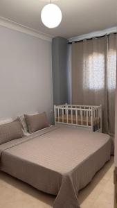 a bedroom with a white bed and a window at Studio Prestige - 10min de ParkMall in Sétif