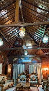 a living room with two couches and a wooden ceiling at شالية الكوخ in Salalah