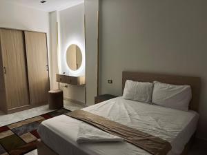 a bedroom with a bed and a mirror on the wall at Neat & Modern Studio 2Mins Pyramids - Royal desert Inn in Cairo