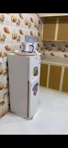 a white refrigerator in a kitchen next to a wall at المربع سويت in Al Qarhāʼ