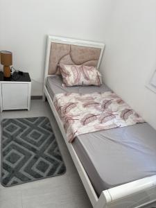 a bed in a room with a white wall at Talia in Bejaïa +8 photos