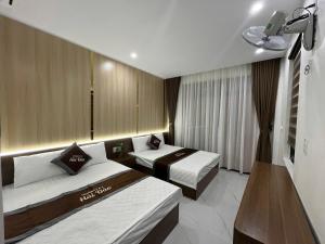a hotel room with two beds and a television at Hải Đảo Homestay in Quan Lạn