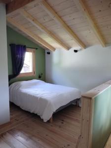 a bedroom with a bed in a room with a window at Le Bâti in Servoz