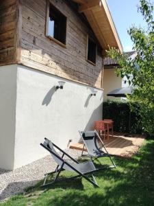 two lounge chairs in the grass in front of a house at Le Bâti in Servoz