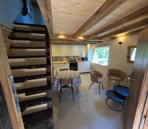 a room with a staircase and a table and chairs at Le Bâti in Servoz