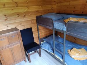 a room with two bunk beds and a chair at Le chalet d'Empeytepas in Céaux-dʼAllègre