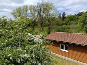 a brown house with a white window and trees at Le chalet d'Empeytepas in Céaux-dʼAllègre +6 photos