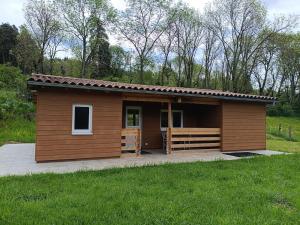 a small cabin with a porch in a field at Le chalet d'Empeytepas in Céaux-dʼAllègre
