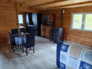 a dining room with a table and chairs in a cabin at Le chalet d'Empeytepas in Céaux-dʼAllègre