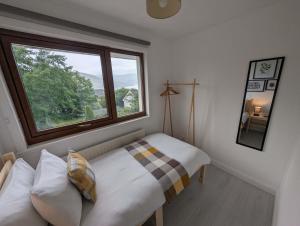 a small bedroom with a bed and a window at Black Sheep Bunkhouse in Fort William