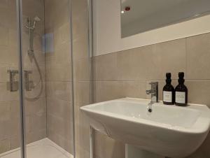 a bathroom with a sink and two bottles of wine at Black Sheep Bunkhouse in Fort William