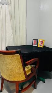 a bed with a black mattress and a chair at 52Golfcourseview guest house in Pimville +5 photos